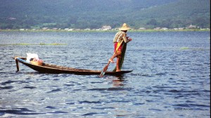 Remando con una pierna y echando las redes en el lago Inle